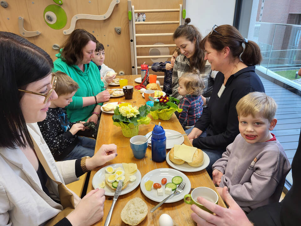 Mütter mit Kindern sitzen an einem Tisch.