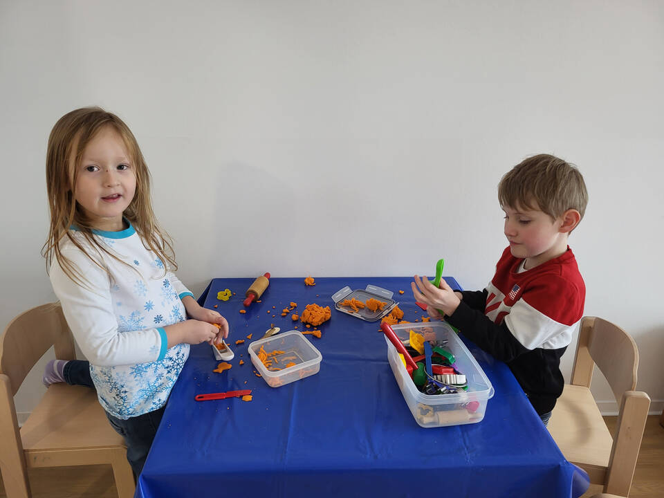 Zwei Kinder spielen mit Knete.