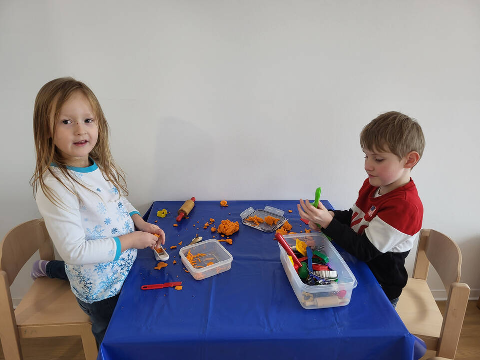 Zwei Kinder spielen mit Knete.