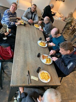 Einige Menschen sitzen am Tisch und essen.