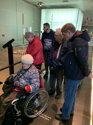 Eine Gruppe Menschen schaut die Ausstellung an.