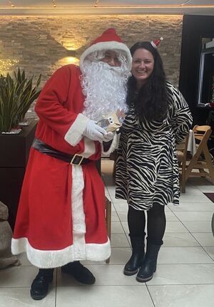 Der Nikolaus steht neben einer Frau in einem Kleid.