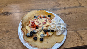 Ein Pfannkuchen mit Früchten und Sahne.
