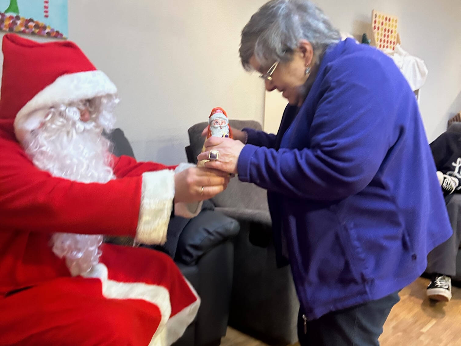 Eine Frau bekommt einen Schokonikolaus vom Nikolaus.