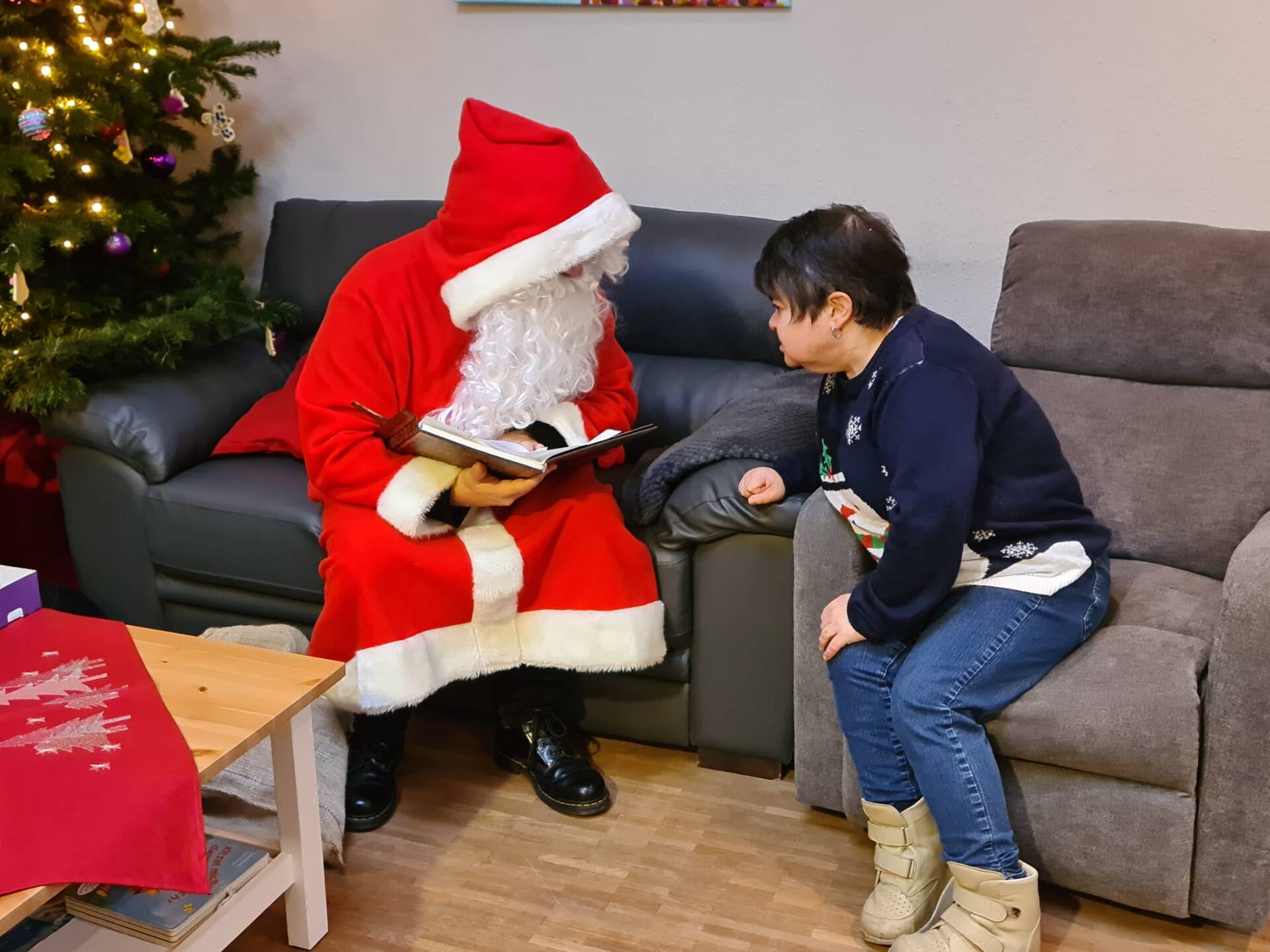 Eine Dame im Sessel hört dem Nikolaus zu.