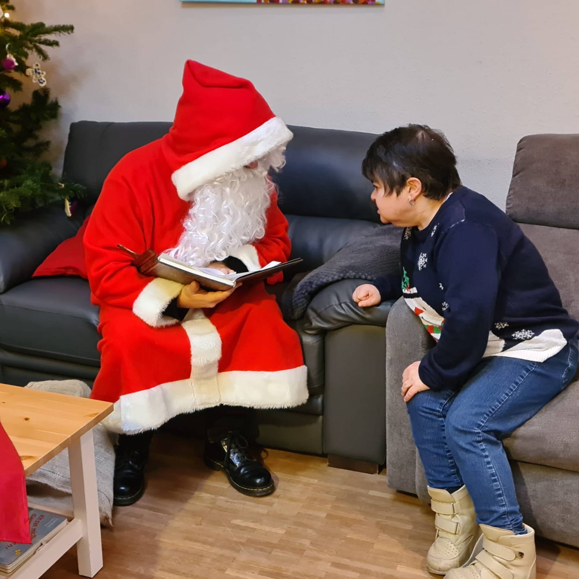 Eine Dame im Sessel hört dem Nikolaus zu.