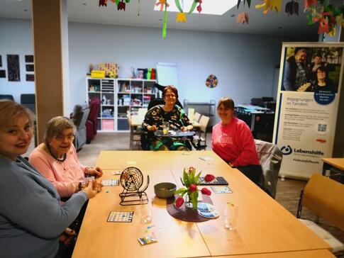 Frauen sitzen gemeinsam am Tisch und spielen.