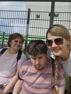 Drei Personen, eine Frau mit Sonnenbrille.