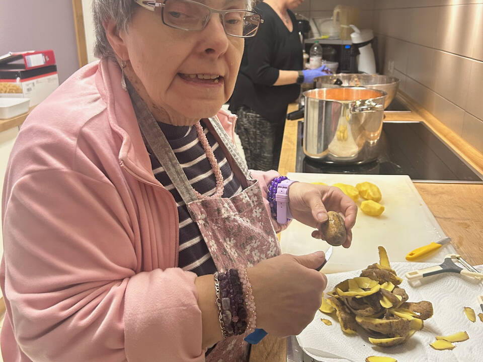 Eine Frau schält Kartoffeln.