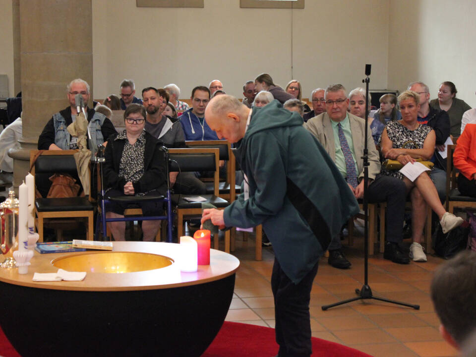 Ein Mann zündet eine Kerze an.