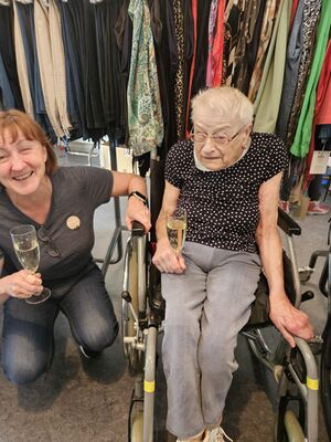 Eine Frau hockt neben einer Person im Rollstuhl.