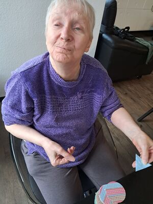 Eine Frau sitzt am Tisch und bastelt.