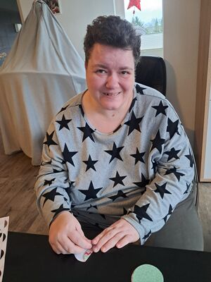 Eine Frau im Sternenpulli bastelt.