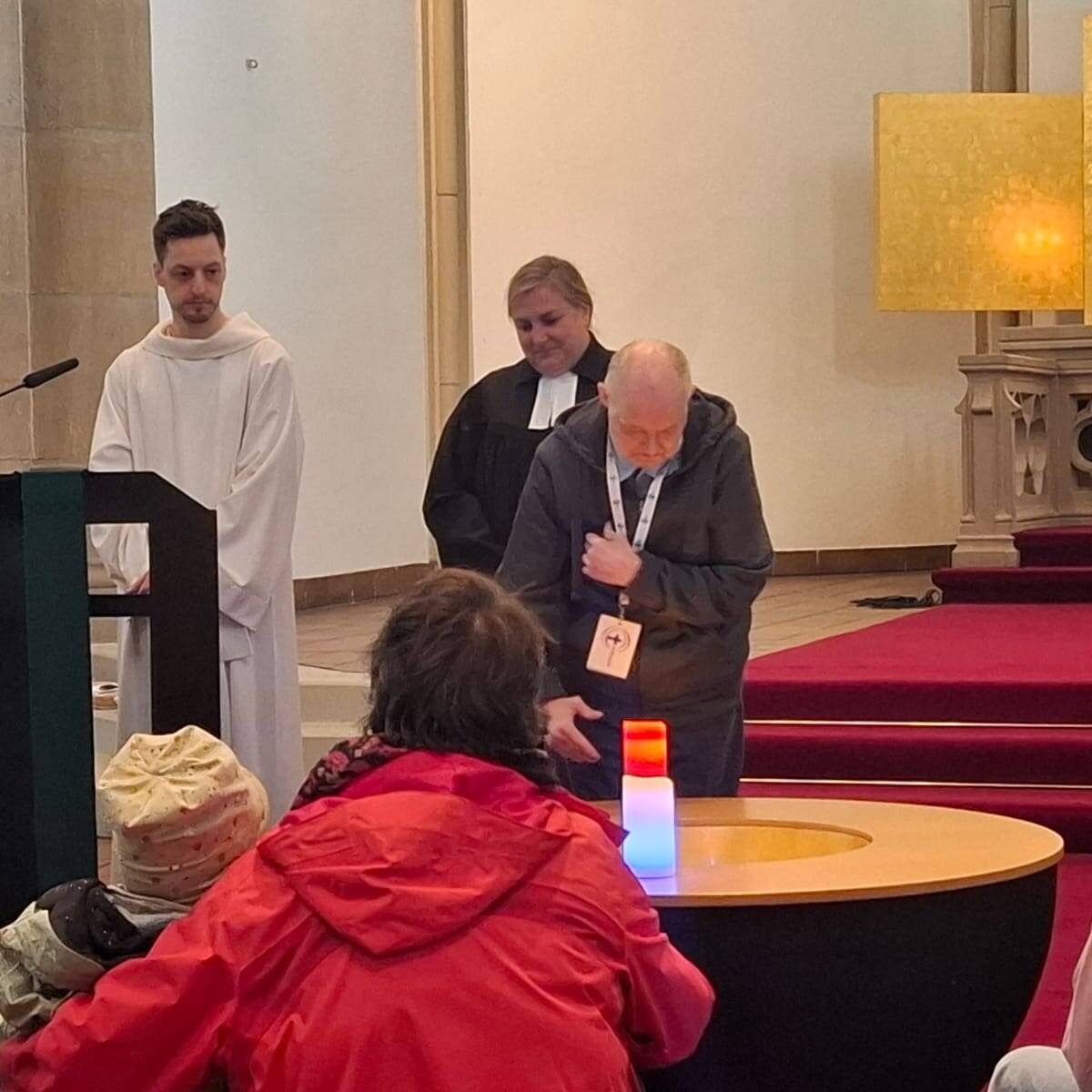 Ein Mensch steht neben Kerzen.