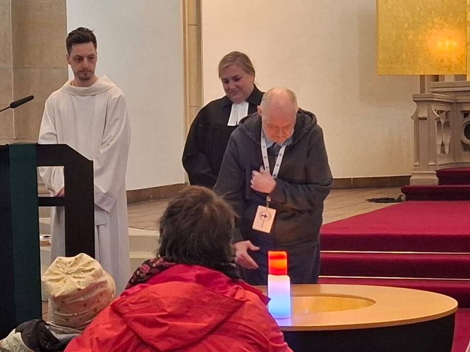 Ein Mensch steht neben Kerzen.