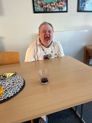 Eine Person drinnen an einem Tisch.