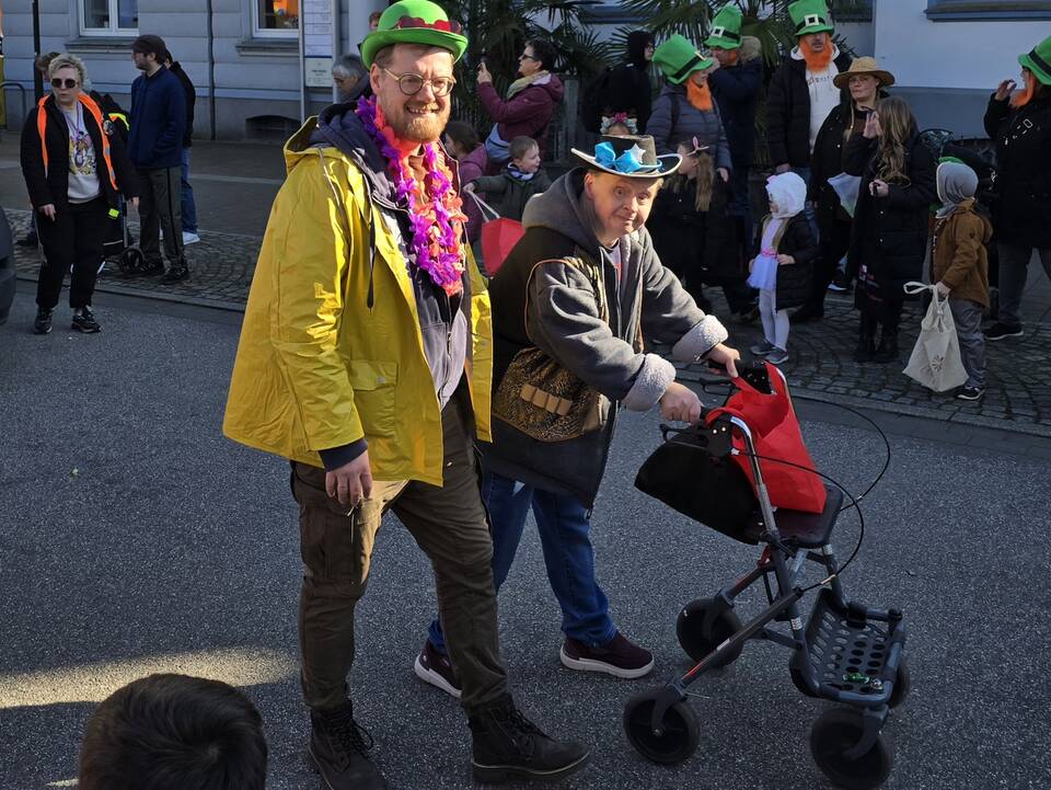 Zwei Personen ein Mann mit einem Rollator.