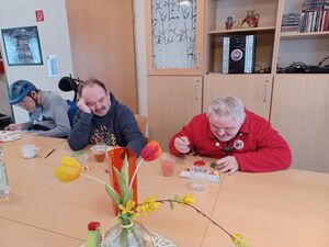 Drei Bewohner malen an einem Tisch.