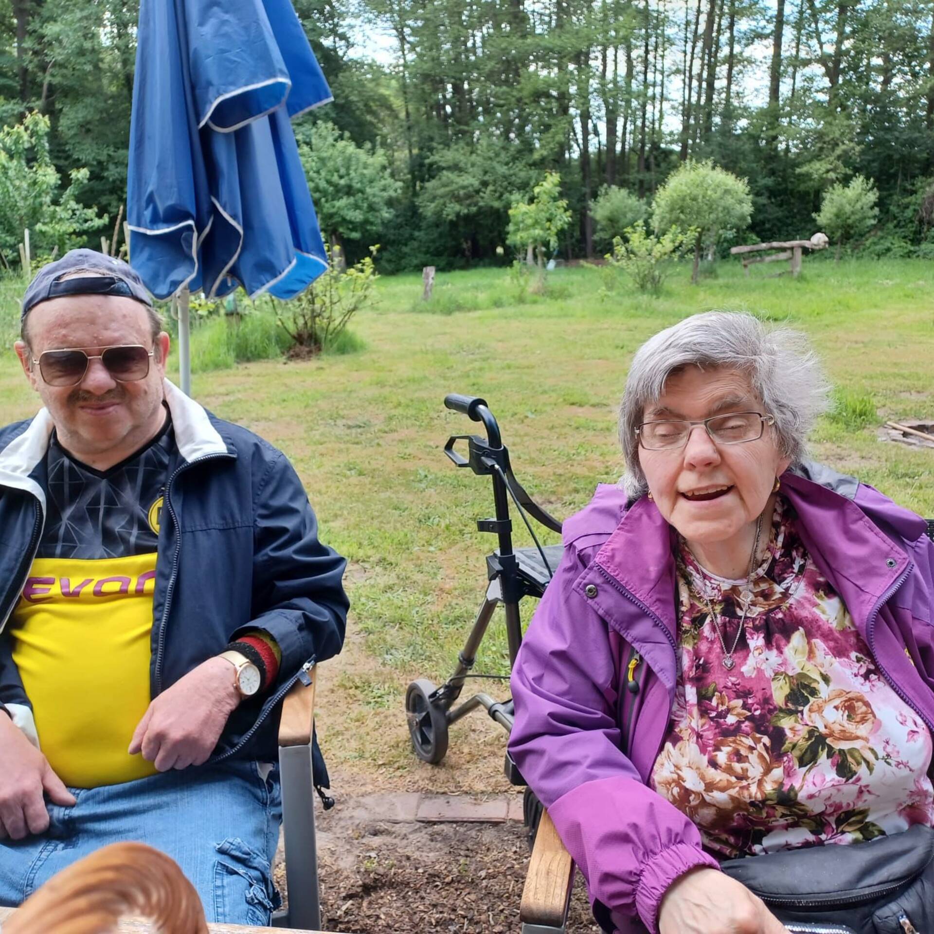 Ein Mann und eine Frau sitzen draußen an einem Tisch.