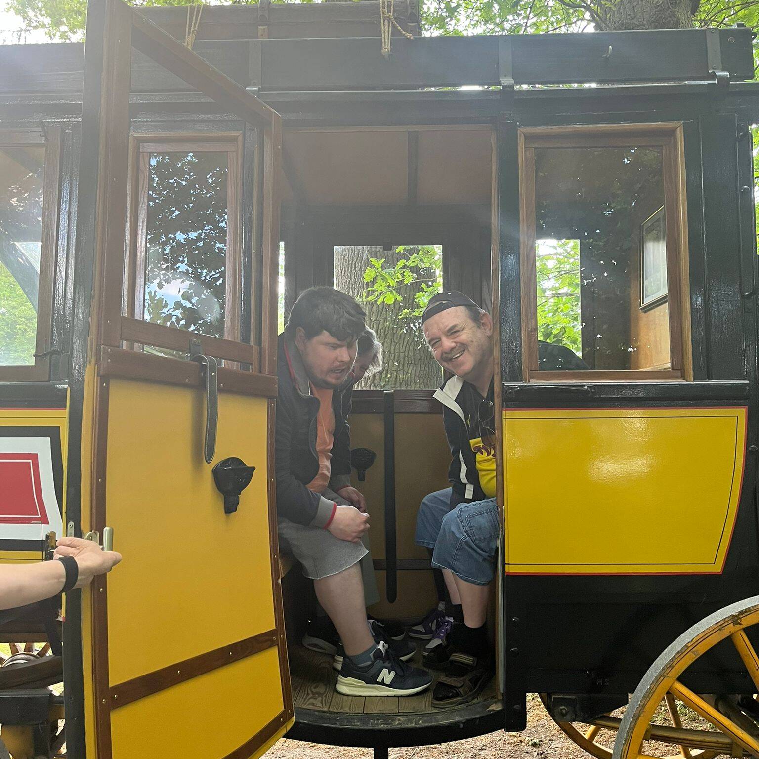 Zwei Personen sitzen in der Kutsche und schauen raus.