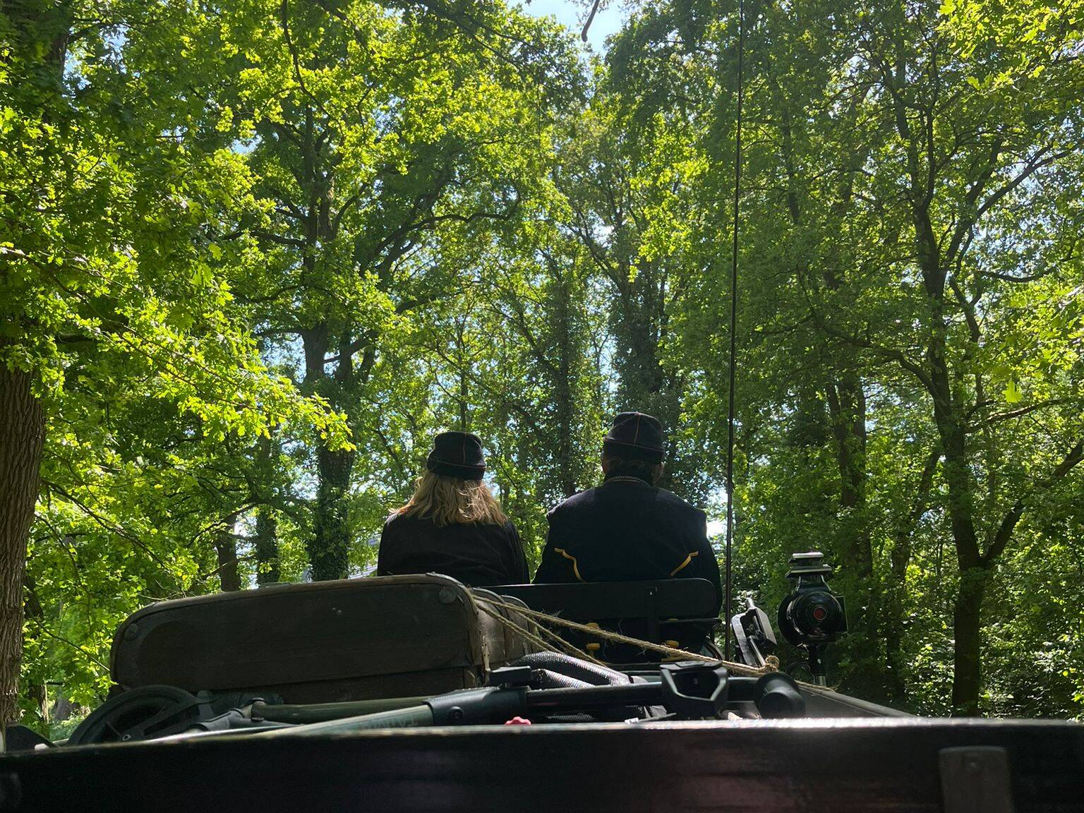 Ein Bild der Kutscher und Kutscherin von hinten.