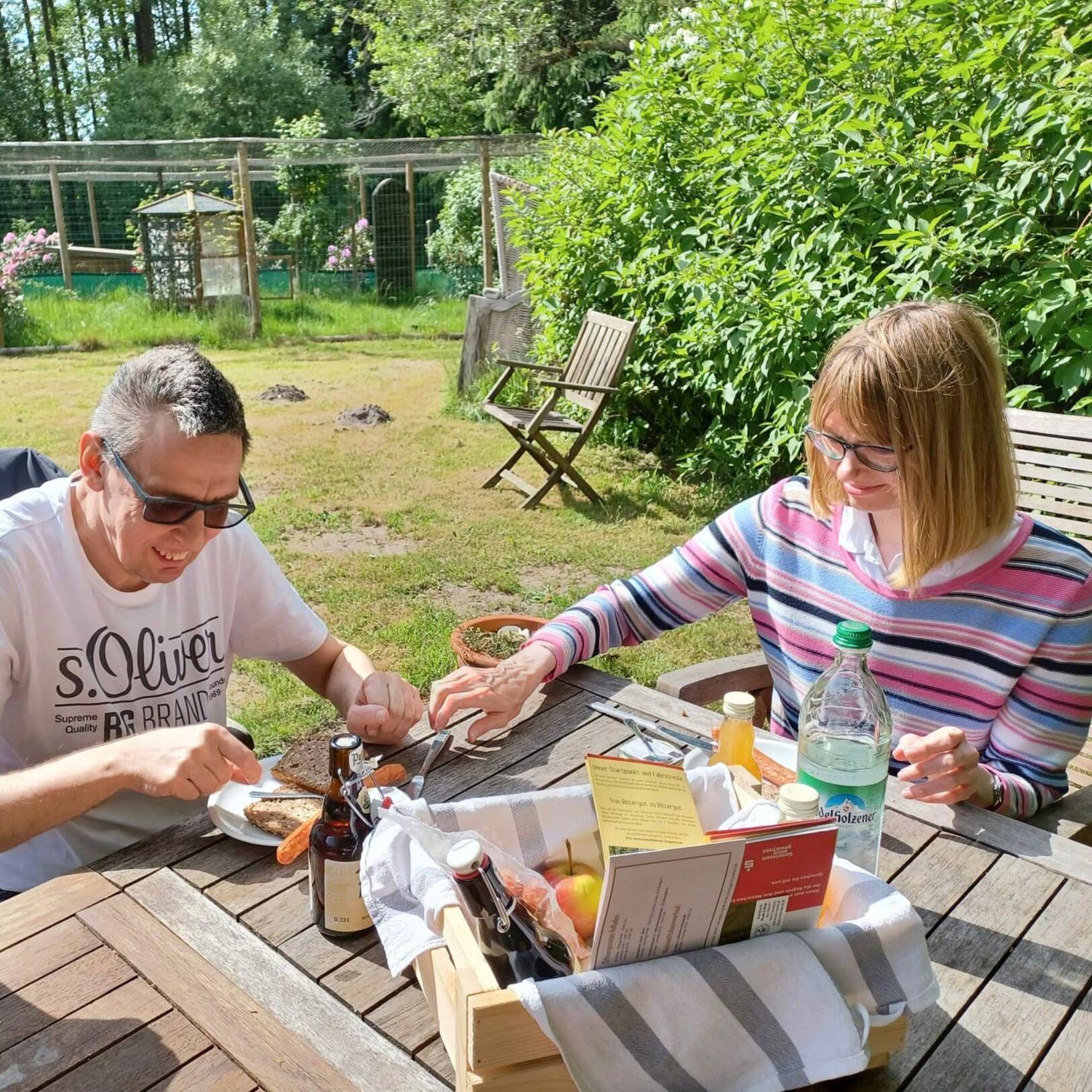 Ein Mann und eine Frau schmieren sich jeweils ein Brot.