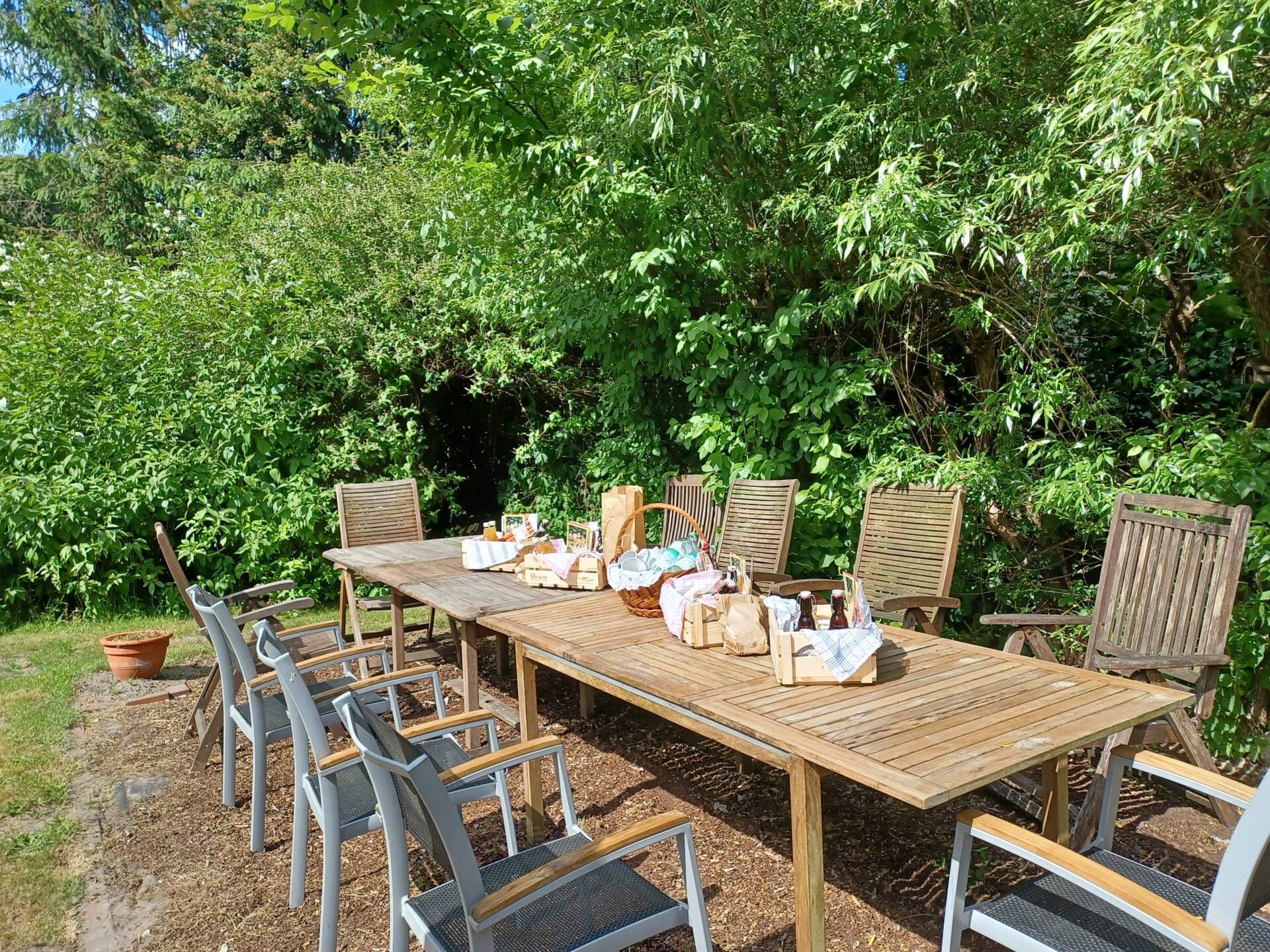 Ein Gartentisch steht in der Sonne und ist gedeckt.