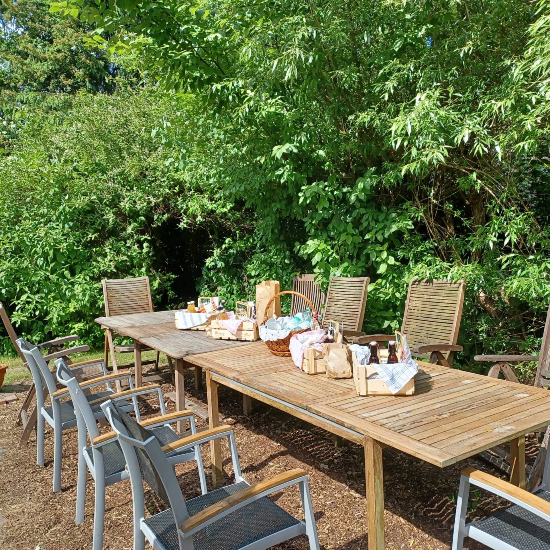 Ein Gartentisch steht in der Sonne und ist gedeckt.