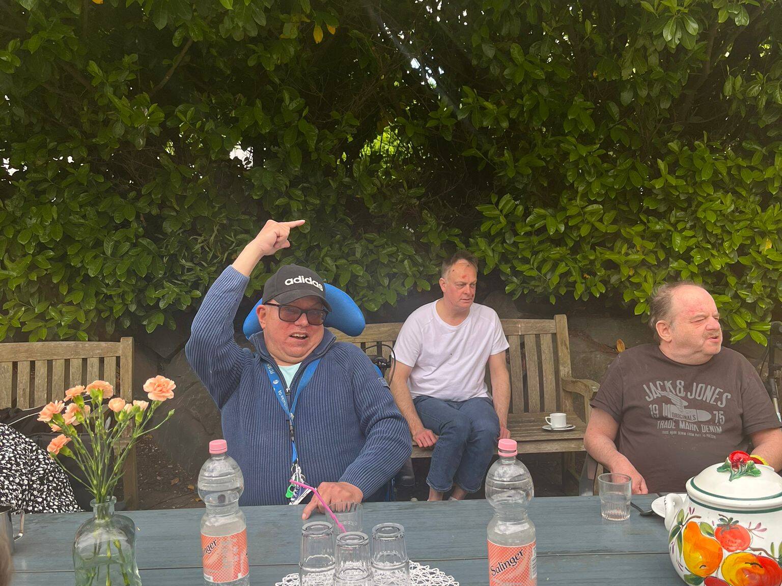 Mehrere Männer sitzen am Gartentisch.