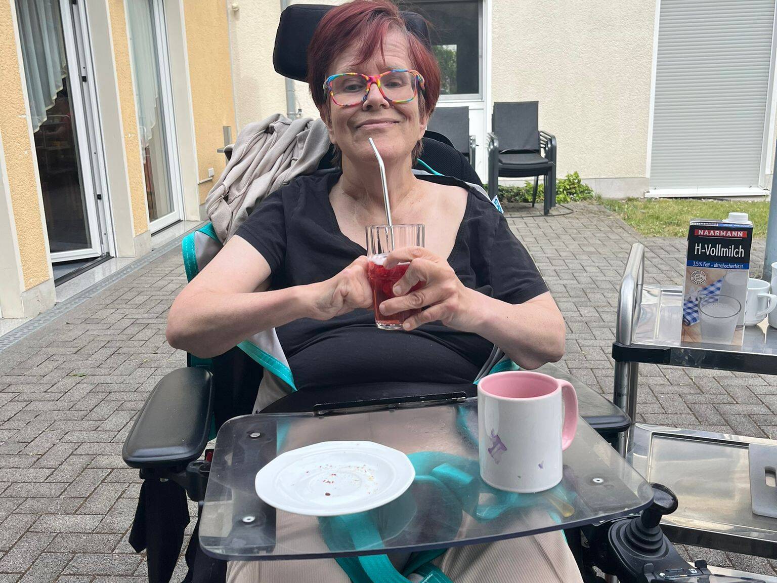 Eine Frau im Rollstuhl lacht.