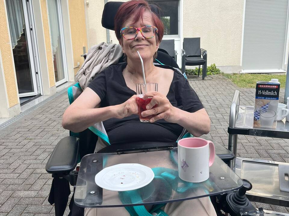 Eine Frau im Rollstuhl lacht.