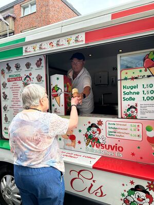 EIn Mann holt sich ein Eis am Eiswagen.