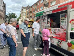 Mehrere Personen stehen am Eiswagen an.