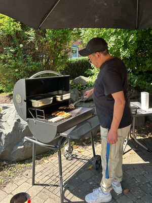 Ein Mann steht am Grill.