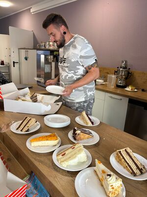 Ein Mann verteilt Kuchen auf die Teller.