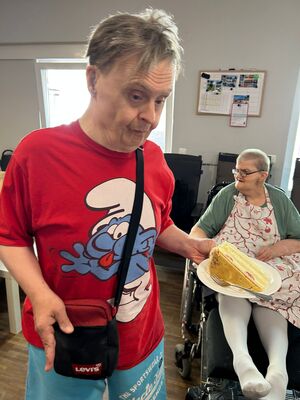 Ein Mann mit einem Schlumpf T-Shirt und einem Stück Kuchen.