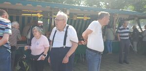 Mehrere Personen neben einem Marktstand.