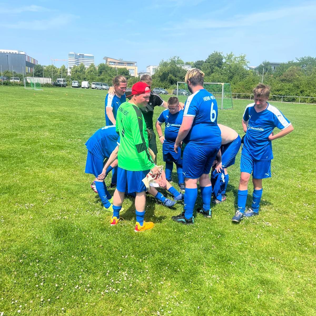 Ein Spieler liegt auf dem Boden, andere stehen drumherum.