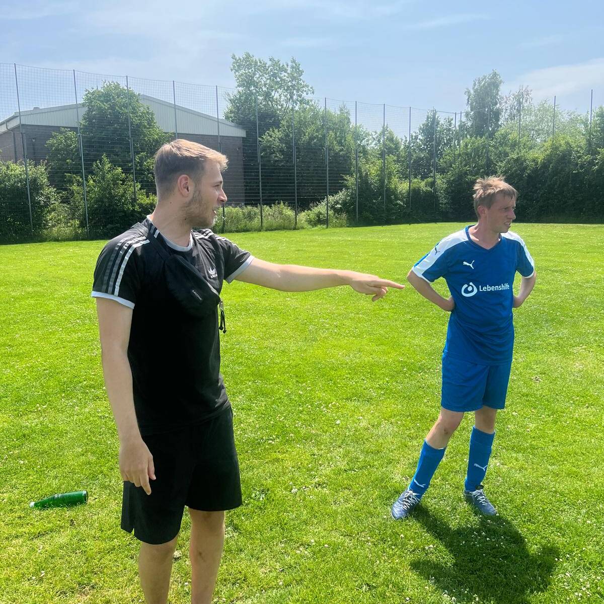 Der Schiedrichter steht neben einem Spieler.