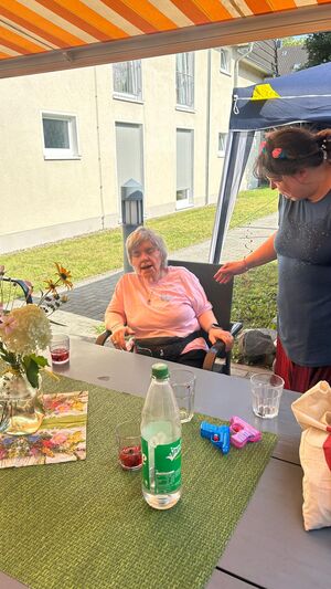 Zwei Frauen unter einer Markise an einem Tisch.