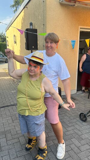 Zwei Personen stehen Hintereinander und halten sich an den Händen.