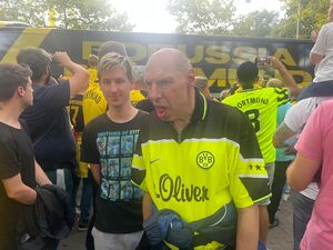 Ein Fan zwischen anderen Fans im Trikot.