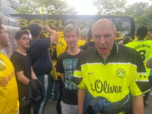 Ein Fan zwischen anderen Fans im Trikot.