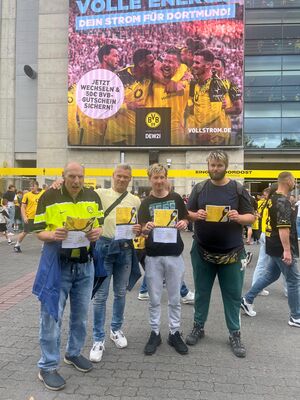 Fans, und ein Begleiter mit Tikets in der Hand, vorm Stadion