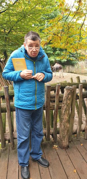 Ein Mann steht am Hirschgehege.