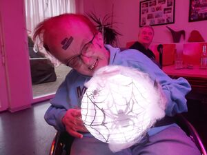 Eine Person im Rollstuhl mit einer Leuchtkugel in den Händen.