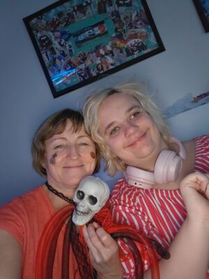 Zwei Frauen lächeln und sitzen in einem Raum.