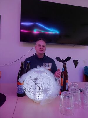 Ein Mann sitzt an einem Tisch und eine Leuchtkugel liegt vor ihm.