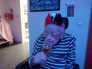 Eine Frau im Rollstuhl trinkt etwas.