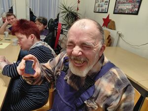 Ein Mann hält etwas in der Hand und lacht.